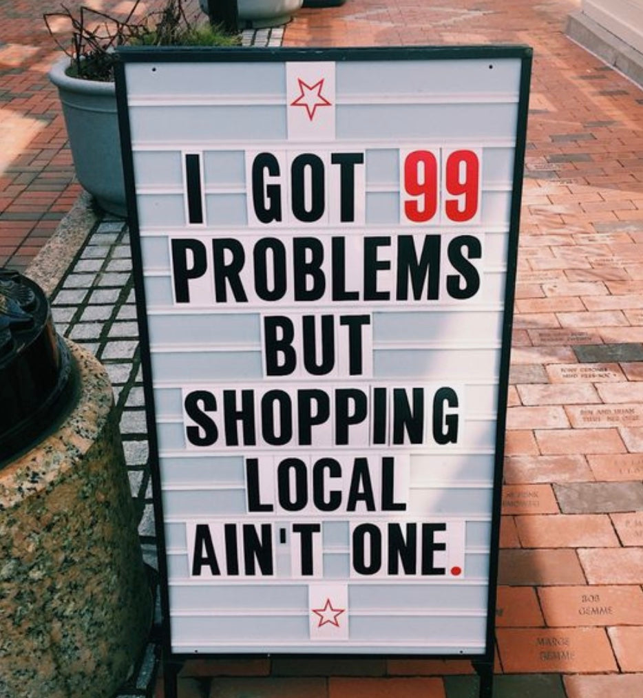 image of a sidewalk sign saying i got 99 problems but shopping local aint one