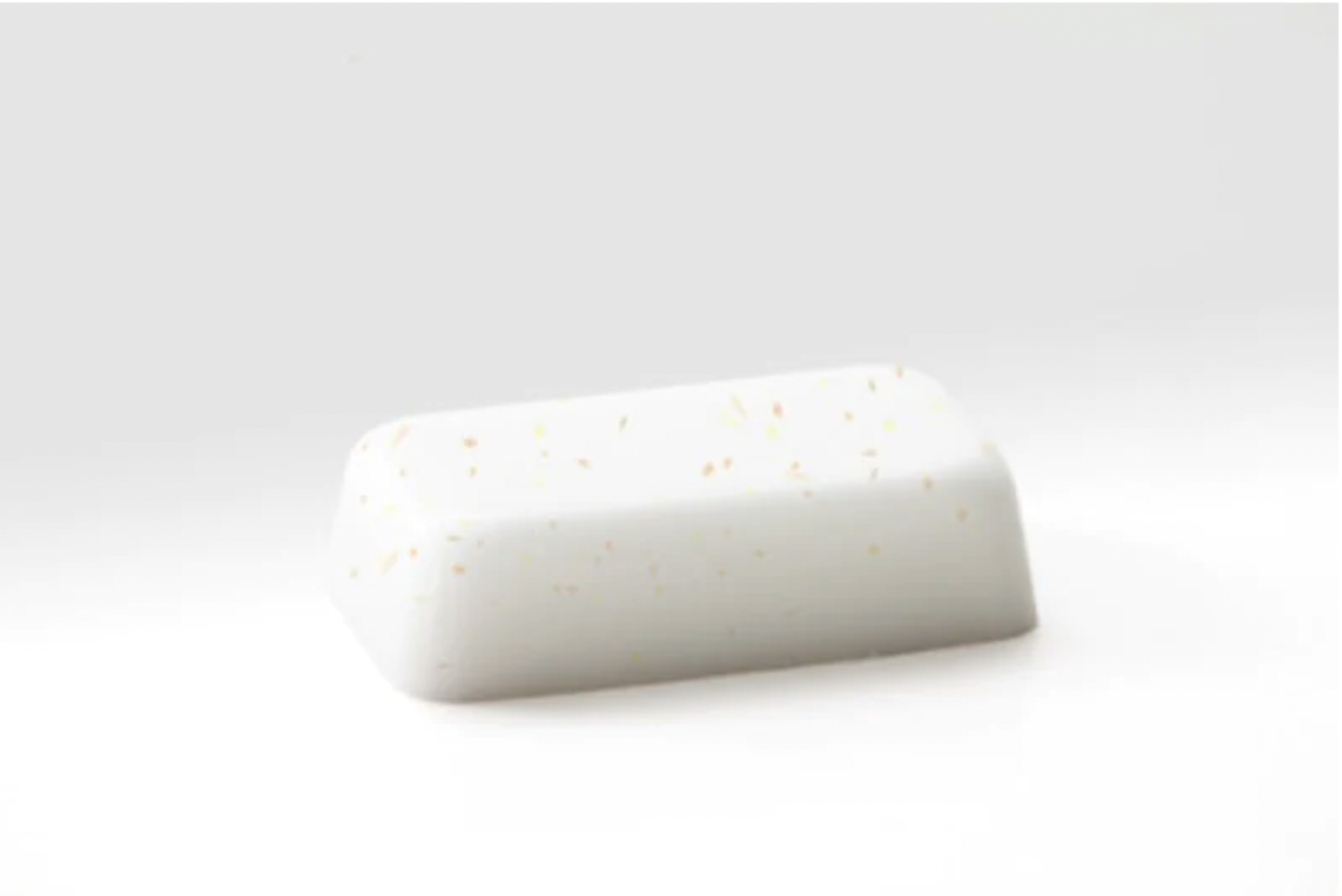 White round bar of soap with yellow speckles