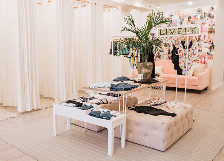 Intimate apparel store lively showcases garments on diversely textured surfaces, like tables and ottomans.