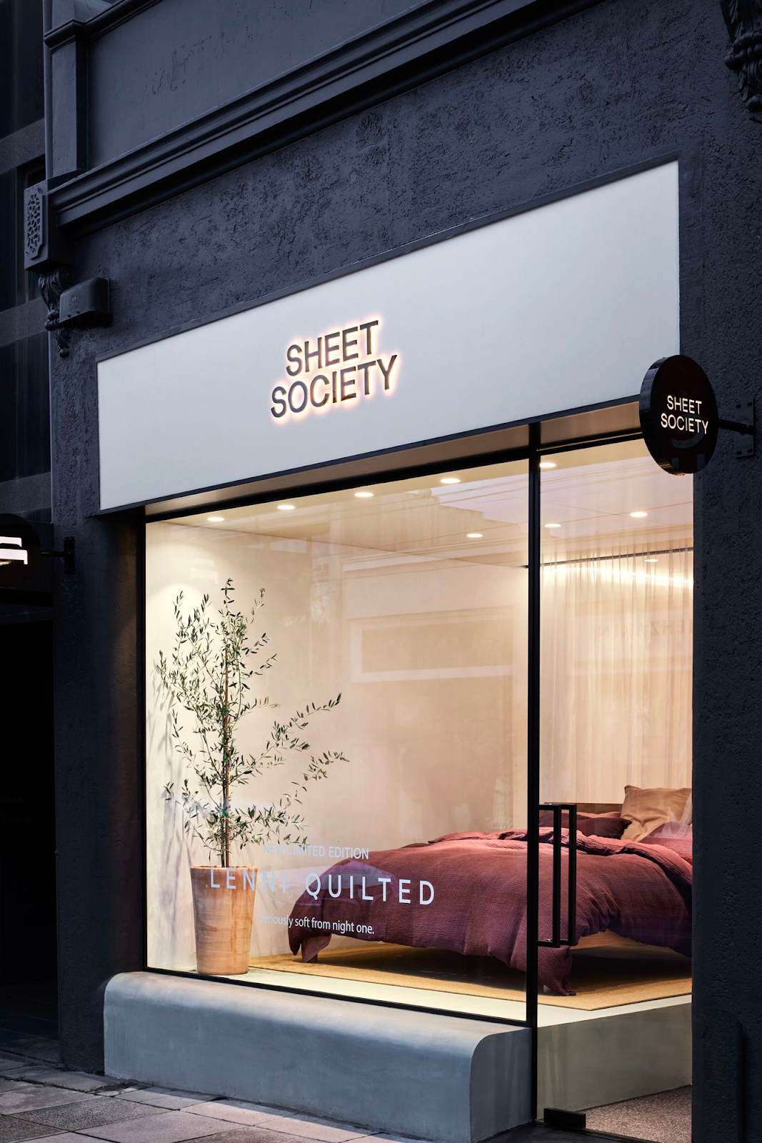 Sheet Society's Armadale store front at night.