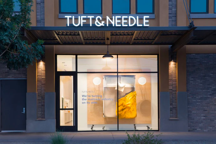 Tuft & Needle's Gilbert, Arizona store front illuminated at night.