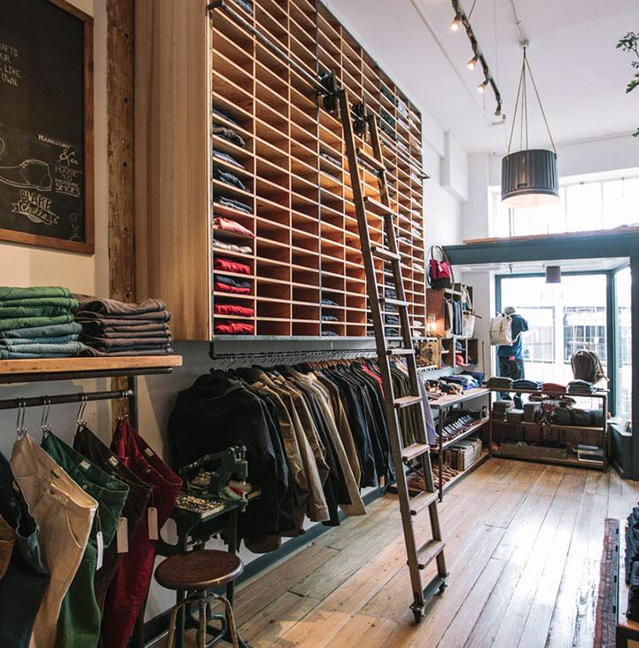 Clothing brand Taylor Stitch displays merchandise on shelves that rise all the way to the ceiling.