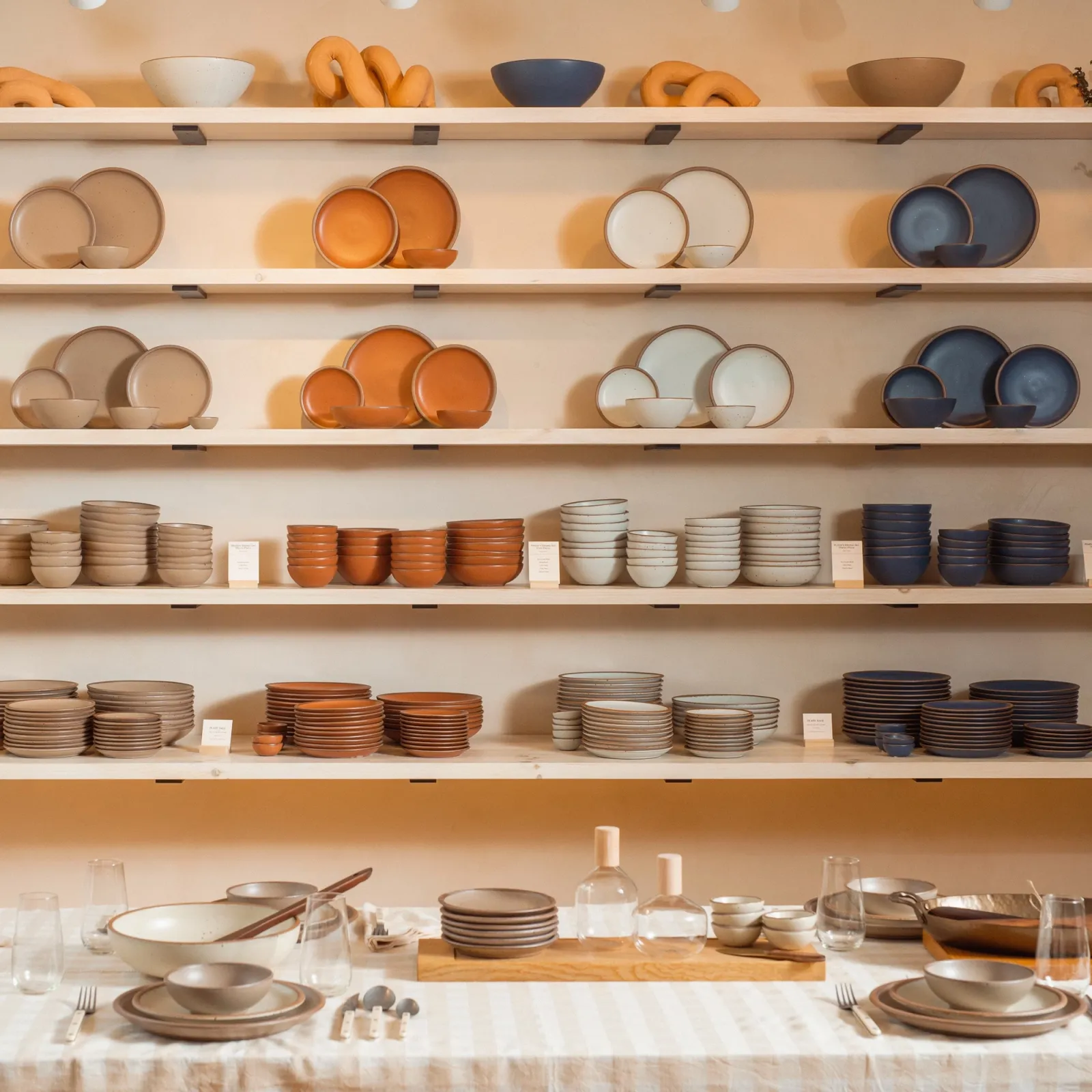Ceramic dinnerware shop East Fork showcases bowls and plates on a tiered wall display.