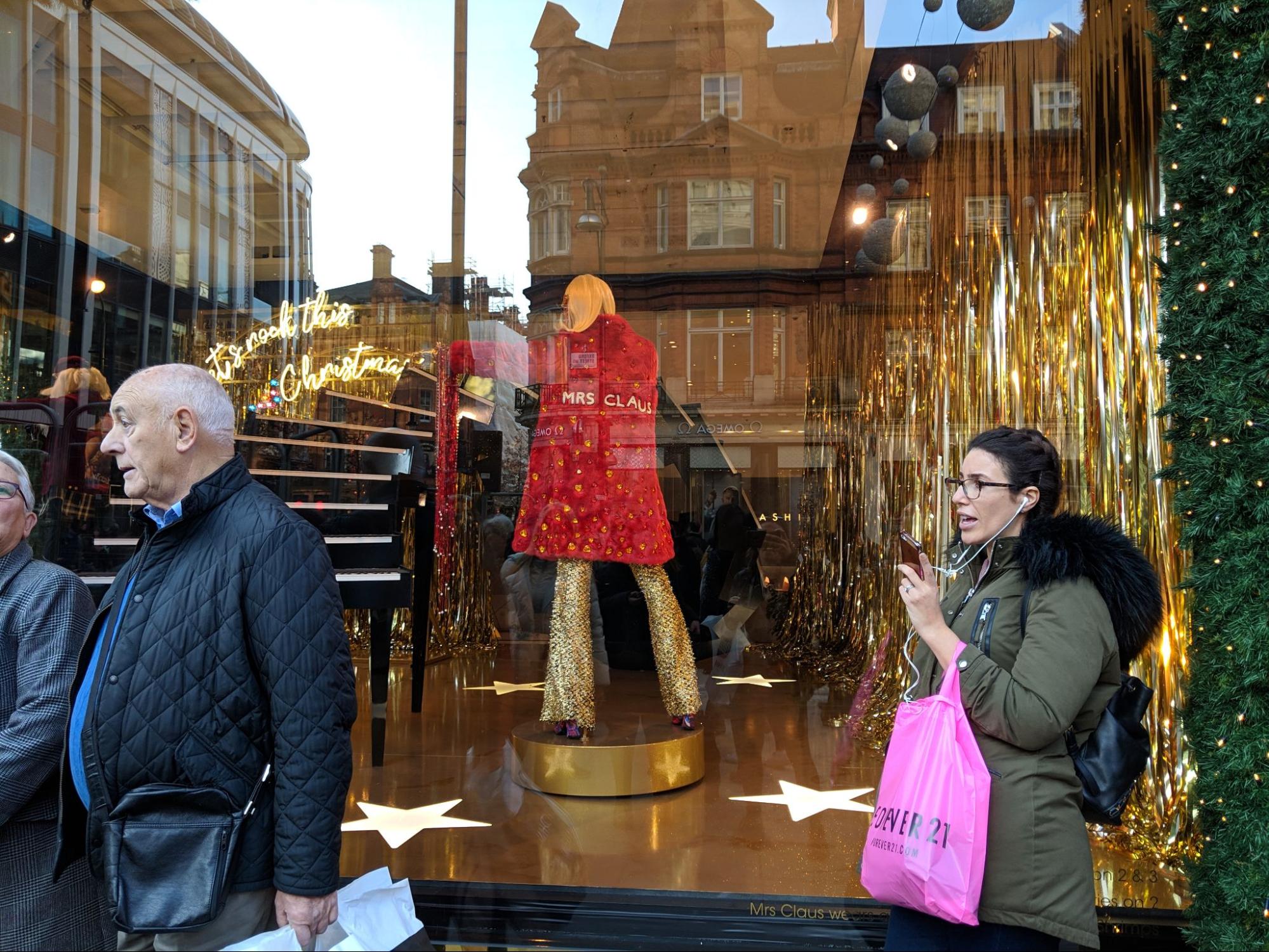 Photo of Christmas-themed window display with a mannequin and tinsel