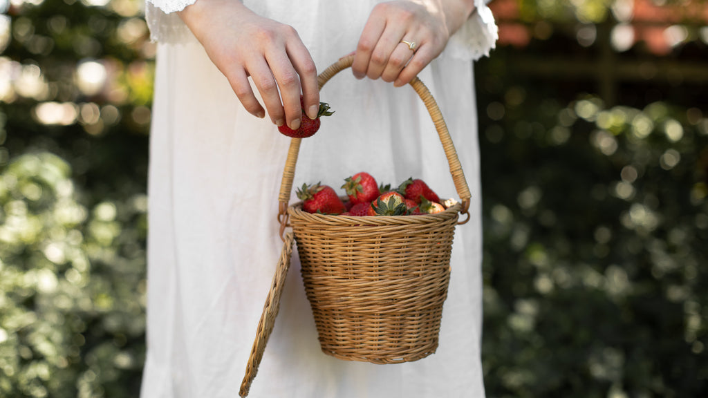 Holding a basket full of strawberries