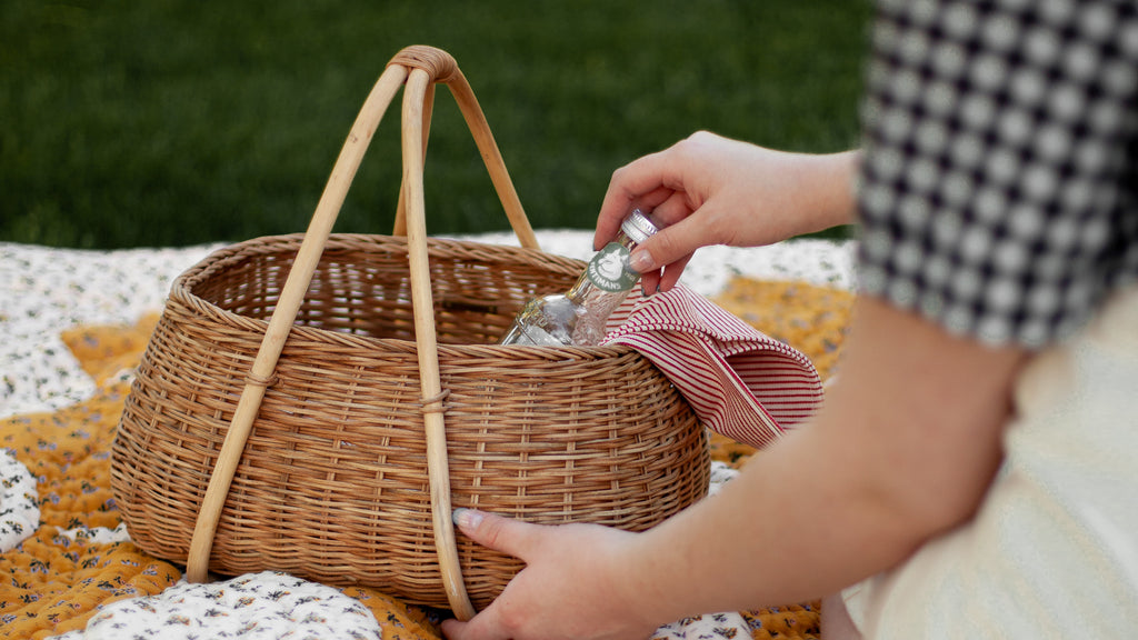 Woman on quilt with picnic basket