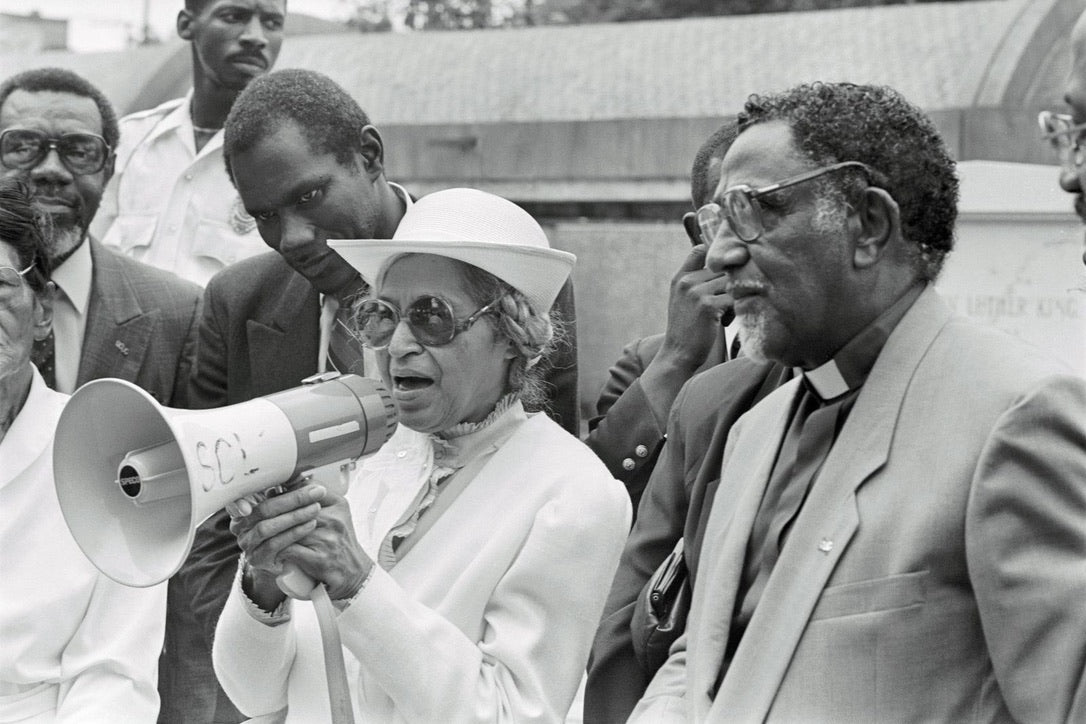 rosa parks speaks to a crowd on a megaphone