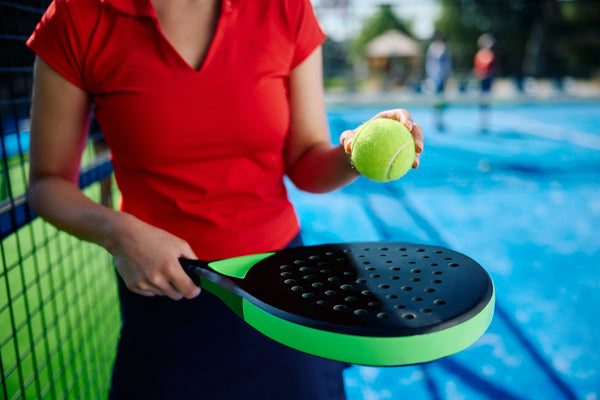 An athlete holding a padel ball - Racquet Point