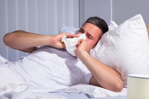 man suffering from dust mite allergies caused by using an old pillow