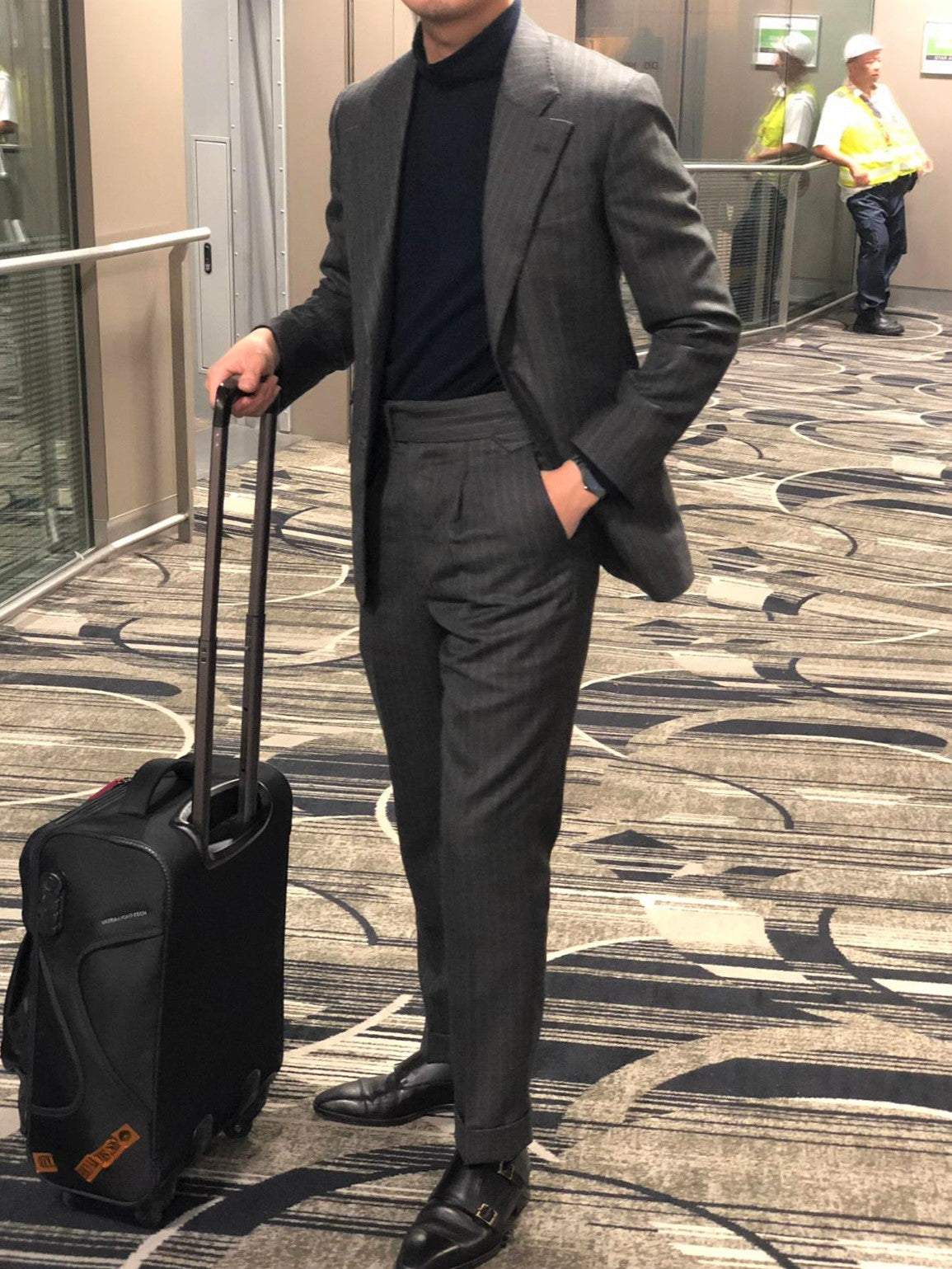 man standing grey chalk stripe suit 