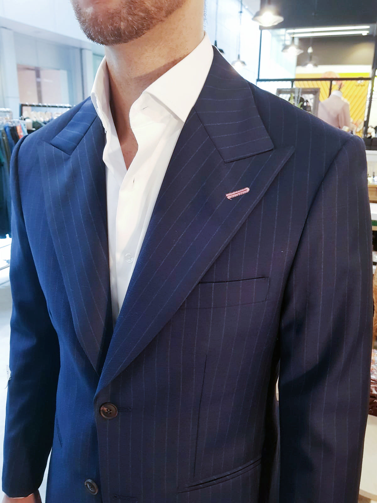 man standing blue chalk stripe suit white shirt