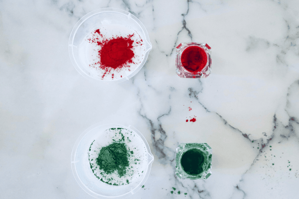 red and green mica powder being added to white soap base