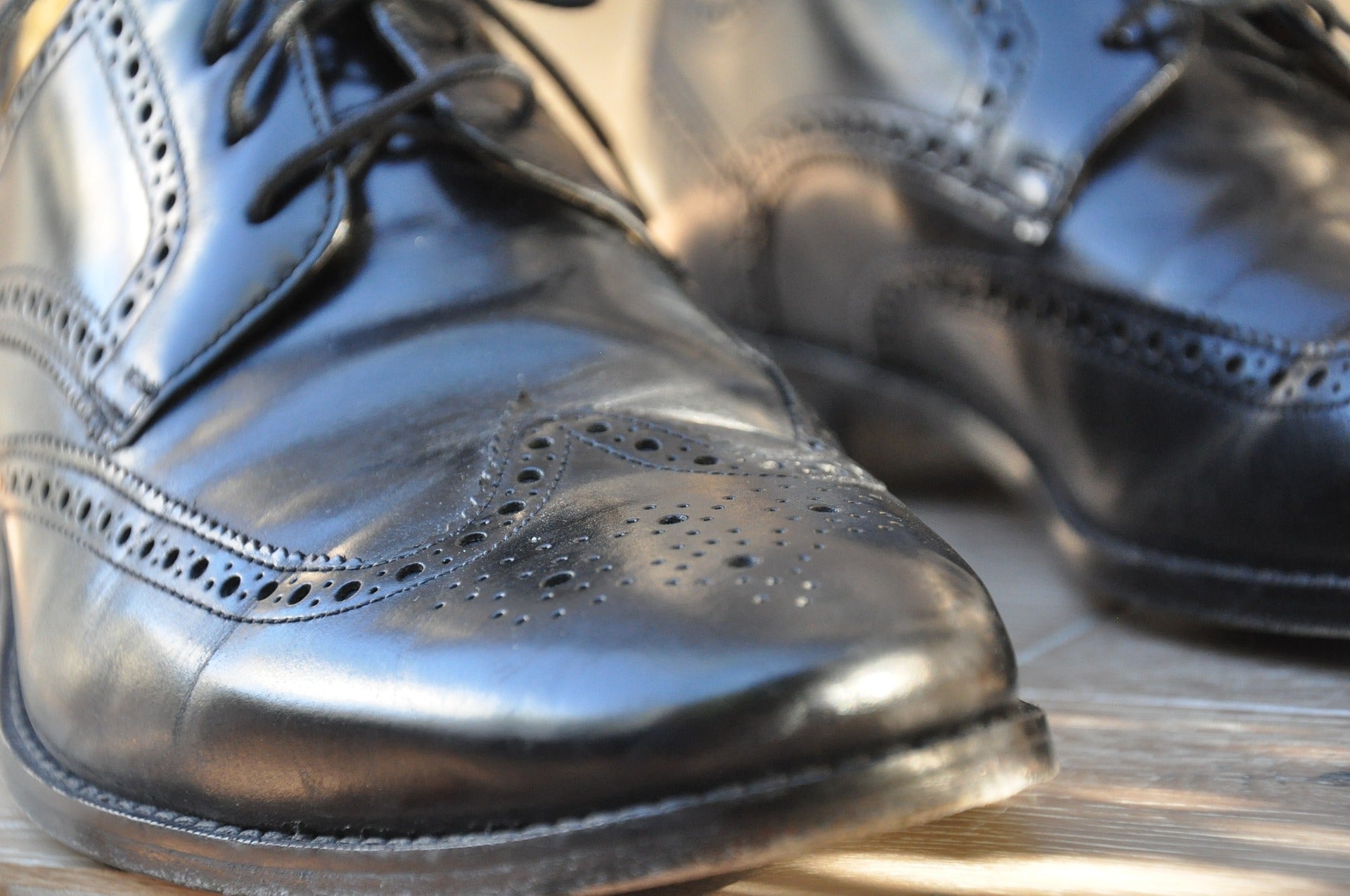 A close-up of a pair of men’s black leather Oxford dress shoes.