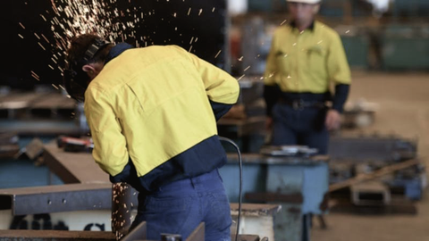 An Australian worker safely works with steel in an Australian steel manufacturing factory.