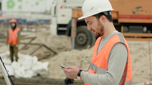 Construction worker in an Australian building site checking social media.