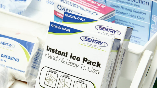 Workplace first aid kit items including instant ice packs, wound dressings, bandages and sterile rinsing solutions.