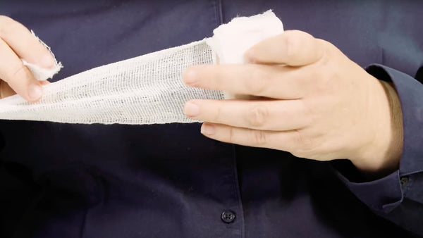 Placing workplace first aid wound dressing with cotton pad face down