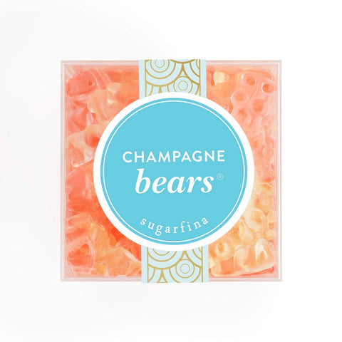 A clear box showcases Sugarfina champagne gummy bears. The bears are tan and pink.