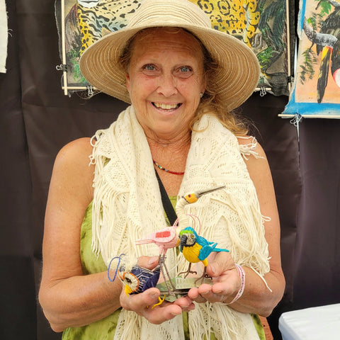 Woman with three chambira palm fiber bird ornaments