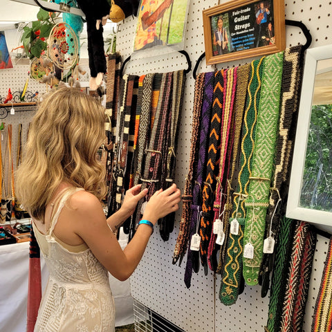 Woman inspecting Amazon guitar straps at the Philadelphia Folk Festival