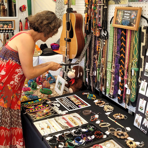 Woman examining Amazon guitar straps at Rhythm and Roots Festival 2022