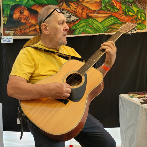 Man playing guitar with Amazon guitar strap at Rhythm and Roots Festival 2022