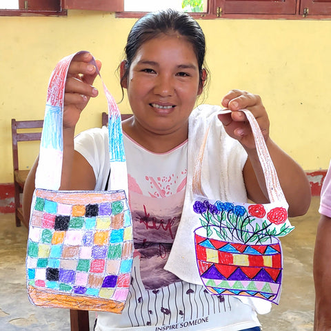 Bora artisan showing two bags made during group creativity exercise at Puca Urquillo