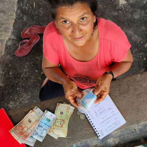 Paquita paying artisans for craft purchases at fair in Amazonas