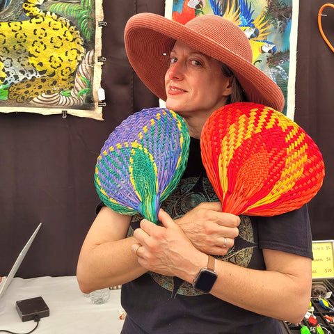 Woman with chambira palm fiber fans made by artisans from the Peruvian Amazon