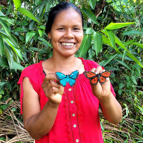Bora artisan Maria Roque with two chambira butterfly ornaments