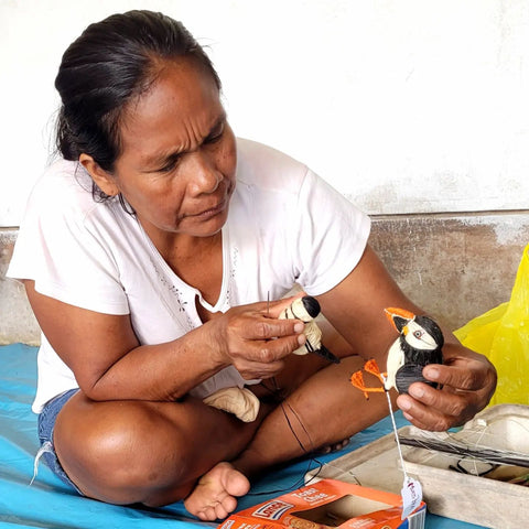 Iris Butuna making chambira puffin ornaments at Amazon Ecology artisan workshop