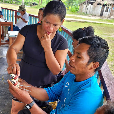 Artisan facilitator Wencenslao Sandi showing Miriam Pinedo how to make a chambira kestrel