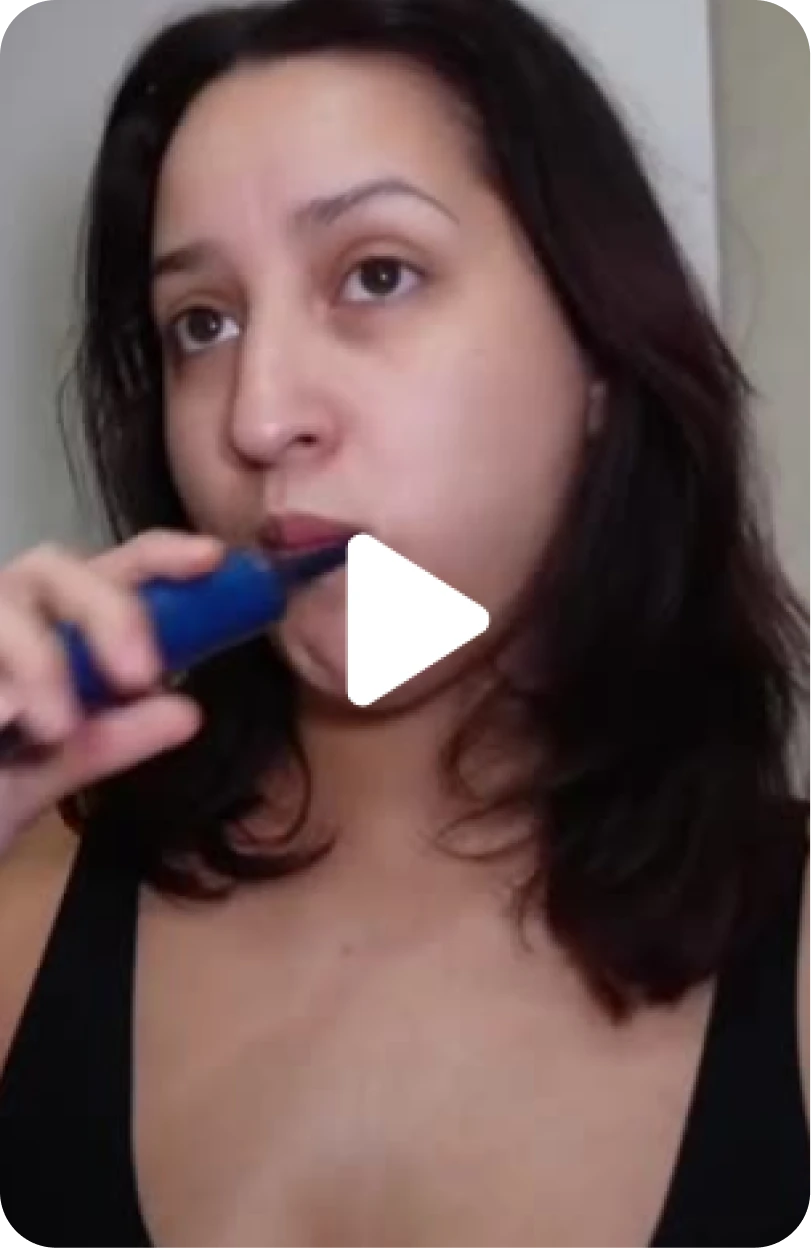 Person in black top using a blue electric toothbrush.