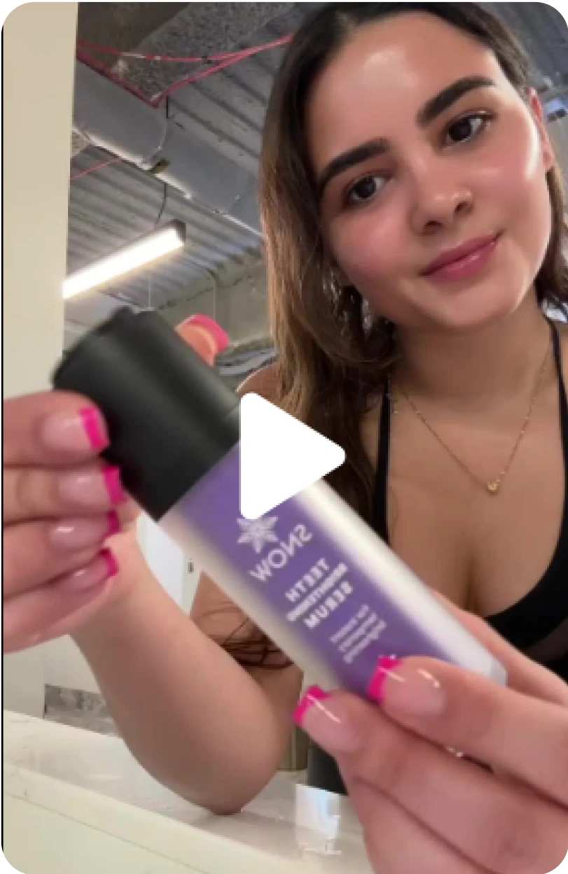 Woman holding a bottle of Snow Extra Strength Serum in front of a camera.