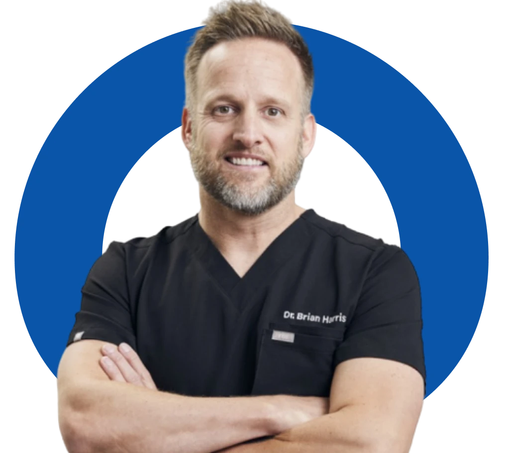 Doctor in black scrubs with arms crossed, in front of a blue circular background.