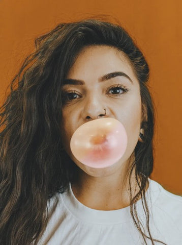 Women blowing bubble while chewing gum