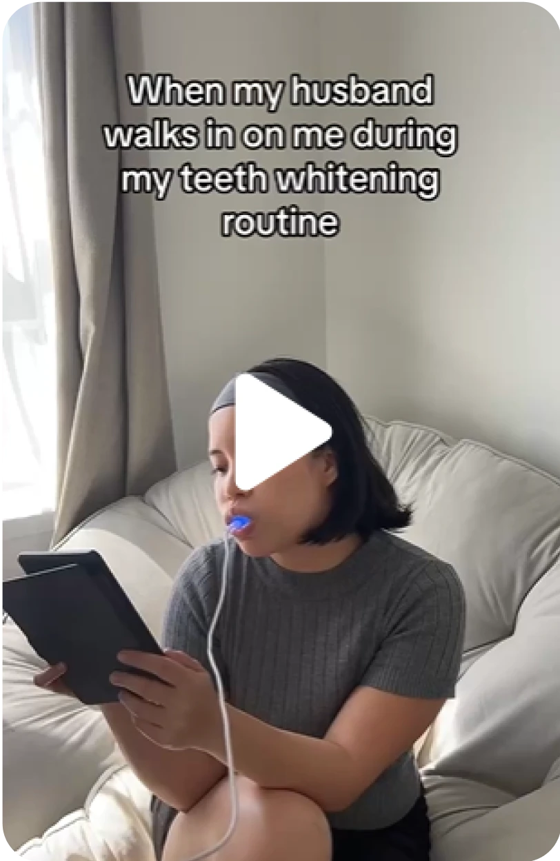 Woman doing teeth whitening routine while reading a tablet. Text reads 'When my husband walks in on me during my teeth whitening routine.'