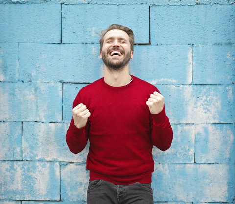 joyful man wearing red t shirt laughing