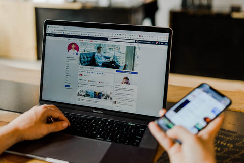 Laptop and mobile phone with Facebook on the screen