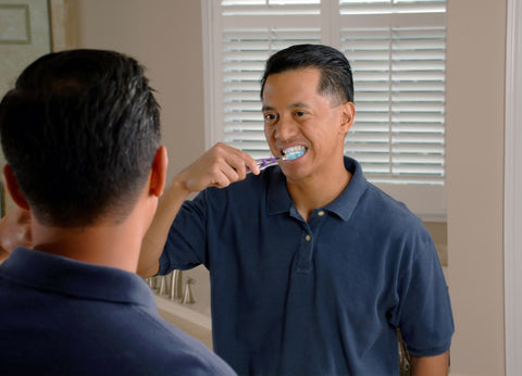 Man in the mirror brushing teeth