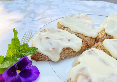 Apple butter scones with white chocolate frosting garnished with purple flowers