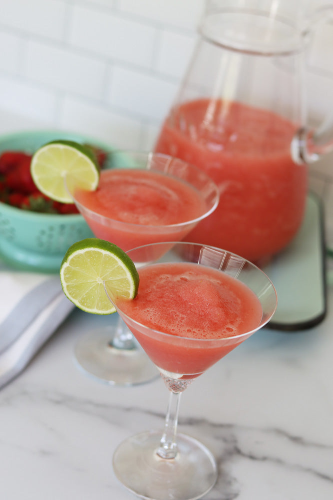 Strawberry daiquiris made with Raven's Nest strawberry jalapeno jam served in martini glasses with limes