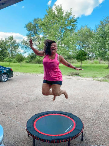 lady jumping on a trampoline outside