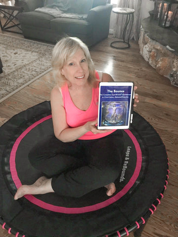 lady sitting on a rebounder with her book