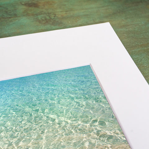an abstract beach and water photograph with a white mat