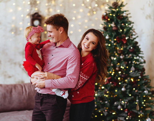 Young parents and a baby by the Christmas tree