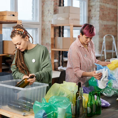 Two women sorting recyling