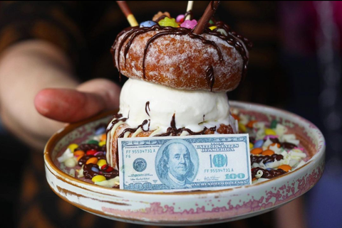 A delicious ice-cream dessert served on a plate with a branded greaseproof paper voucher designed to look like a dollar bill