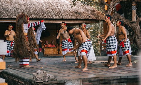 Balinese shirtless men in traditional dance wearing black and white checkered sarong as skirt. 