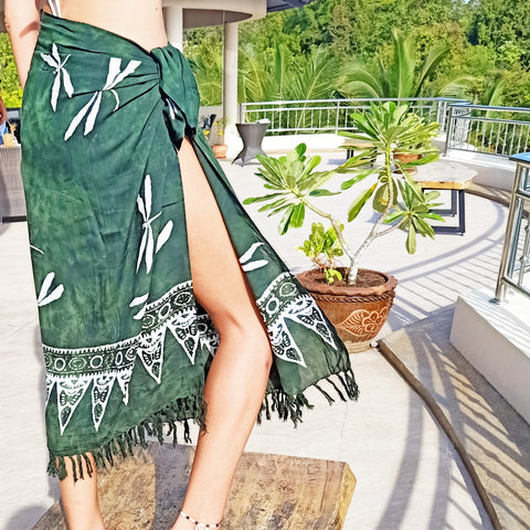 Long green rayon sarong worn as beach wrap skirt with leg showing. 